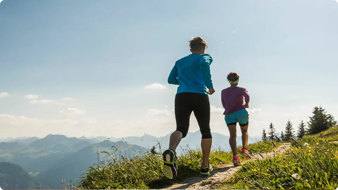 Ein junges Paar joggt in den Bergen